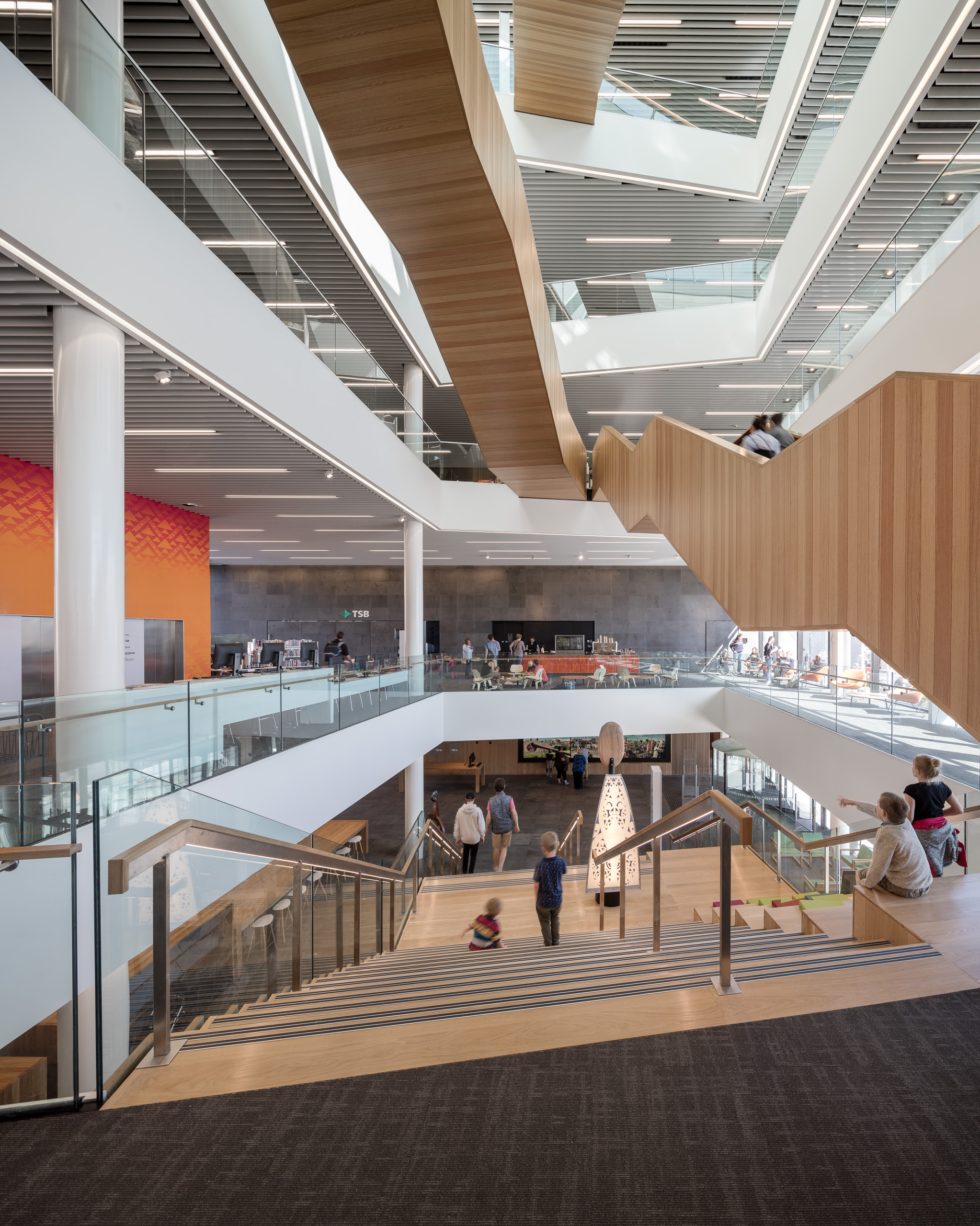 Warm timber staircases and open reading levels inside Tūranga Central Library